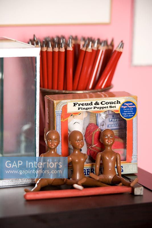 Display of figures and pencils on shelf