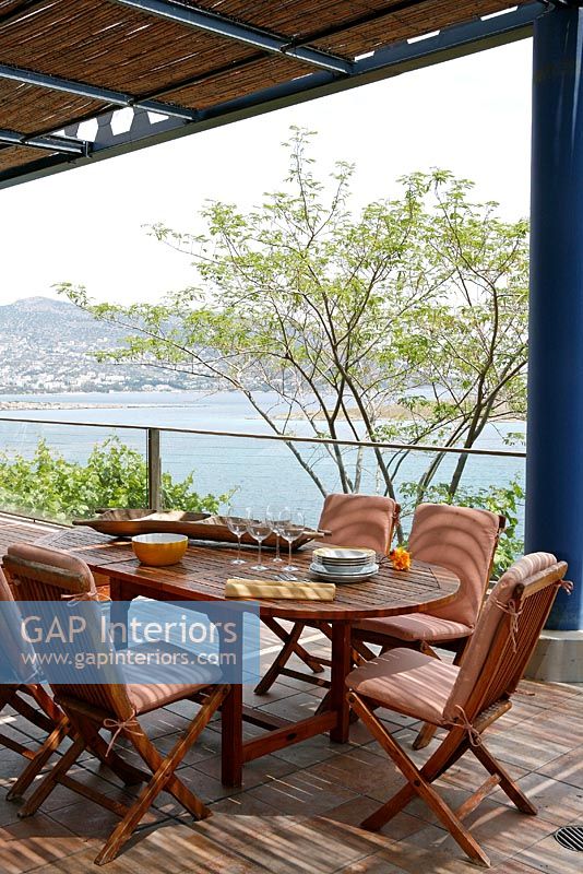 Contemporary dining area on patio with sea view