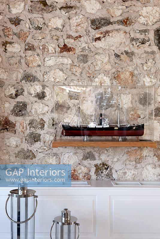 Stone wall and model of ship on shelf