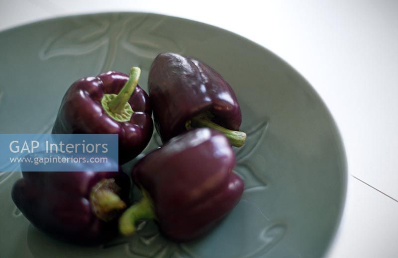 Purple peppers on grey green plate