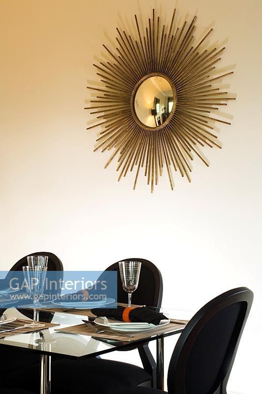 Gold sunburst mirror on dining room wall