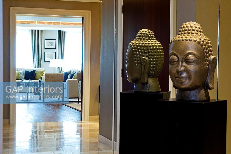 Modern hallway with Buddha sculpture reflected in mirror