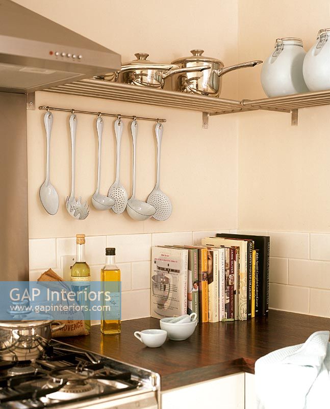 Corner of modern kitchen with metal shelves for pots and pans