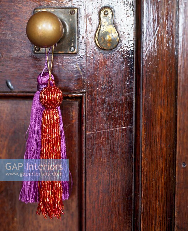 Dark wood door with tassels hanging from handle