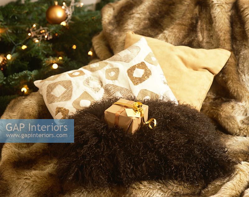 Fur rug and cushions by Christmas tree