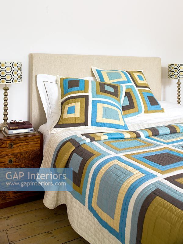 Modern bedroom with bold patterned bedspread 