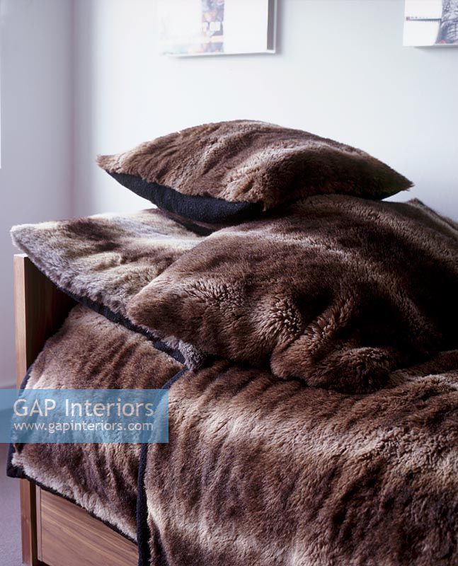 Brown fake fur blankets and cushions detail 