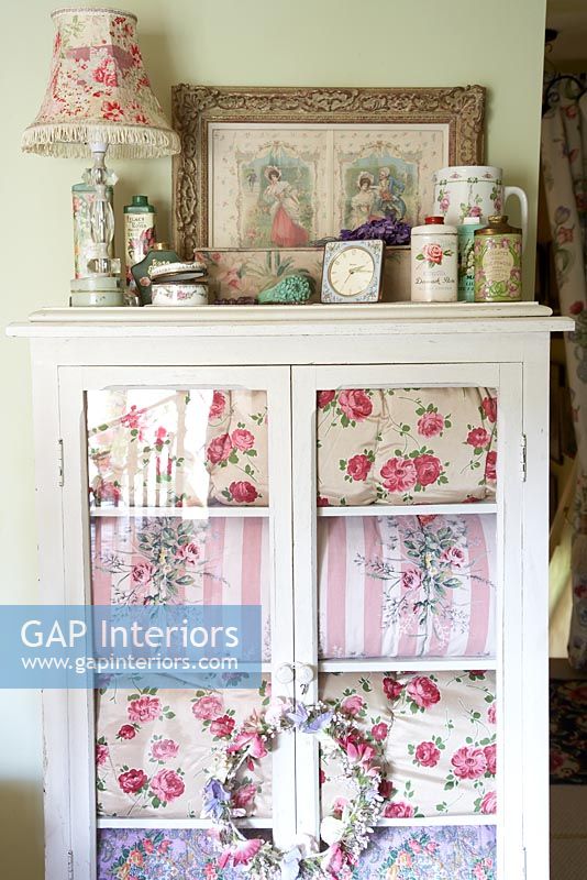 Display cabinet with floral soft furnishings 