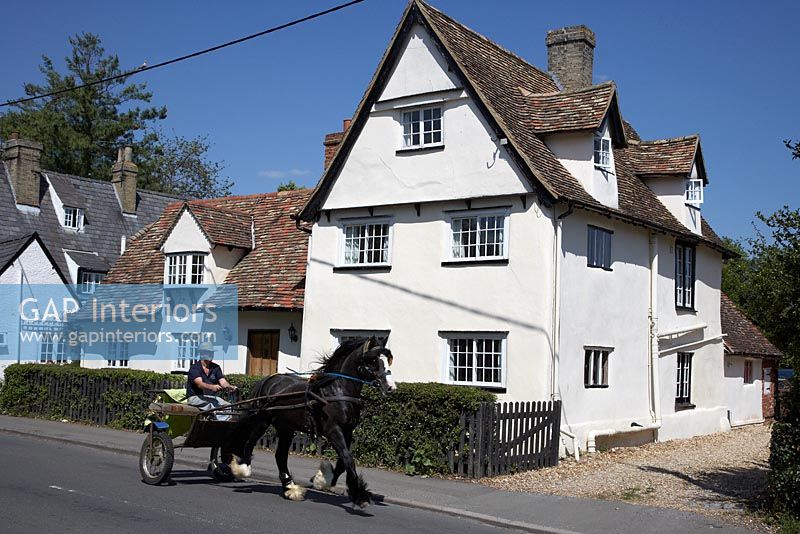 Man on pony and trap outside country house
