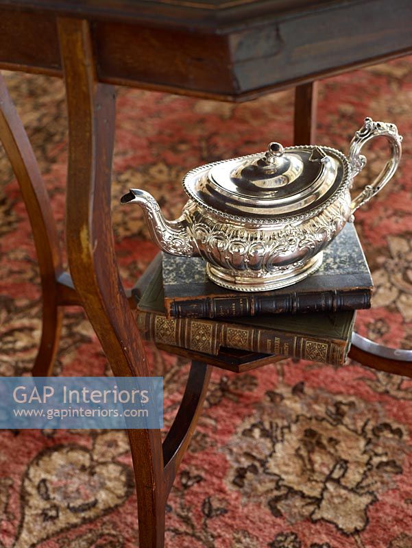Detail of silver teapot and books 