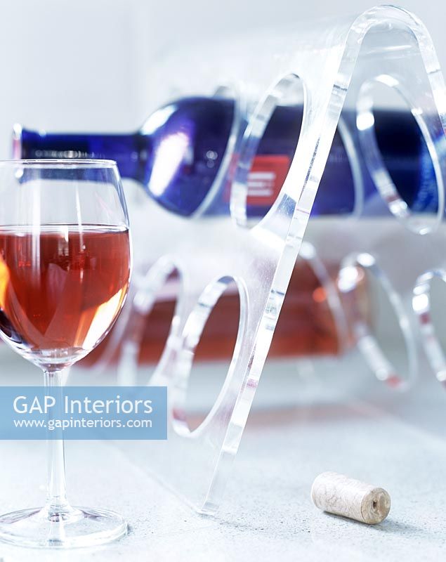 Modern perspex wine rack and glass of wine 