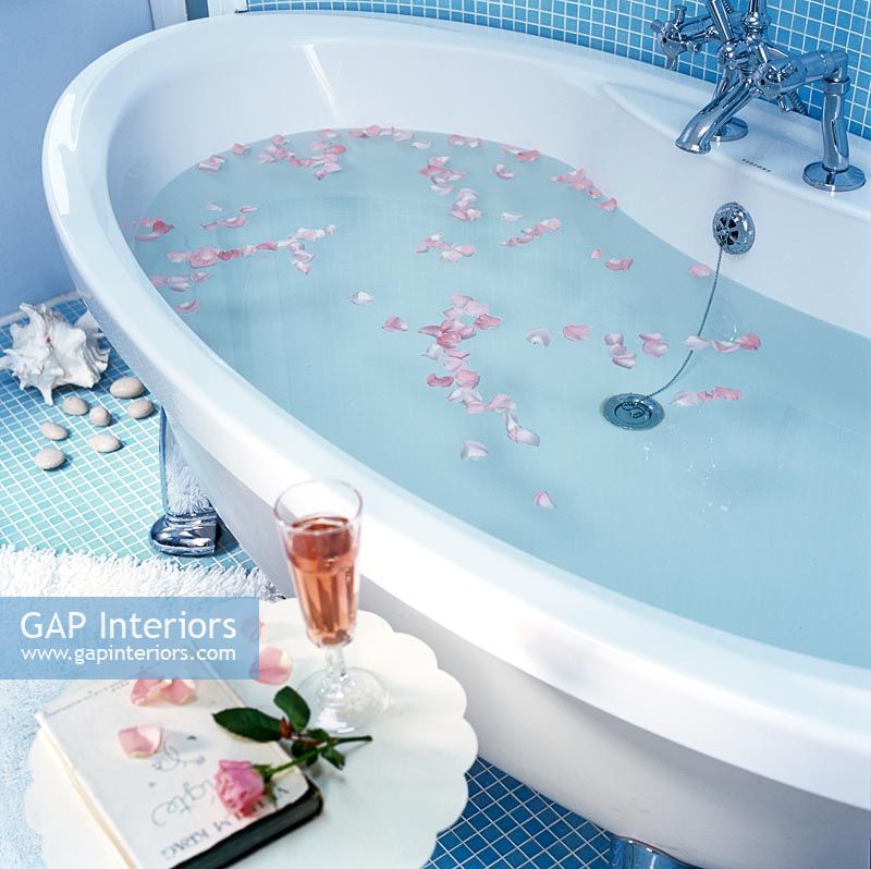 Rose petals floating in modern bath 