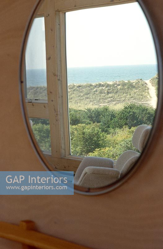 Oval mirror with reflection of sea view