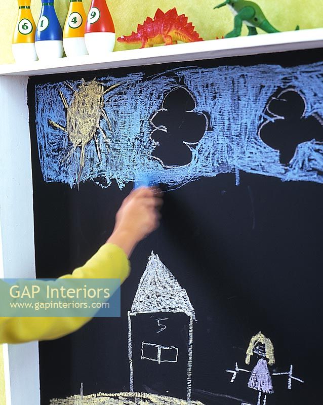 Child drawing with chalk on blackboard 
