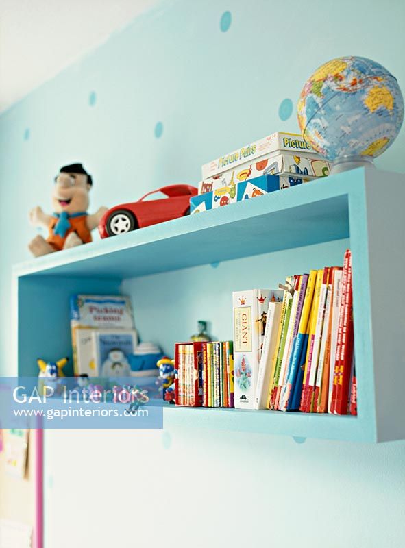 Toys and books on shelves in childrens room 