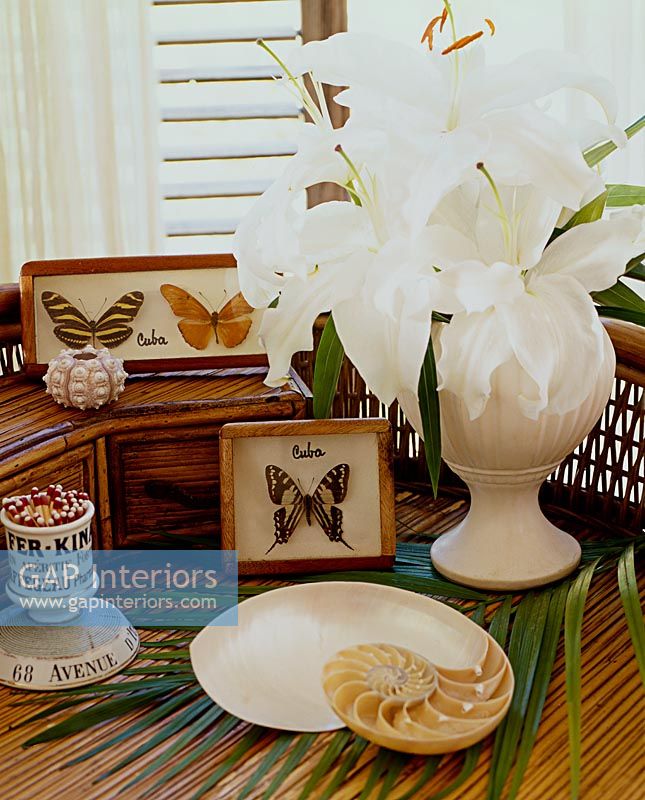 Collectibles and flowers on wicker table