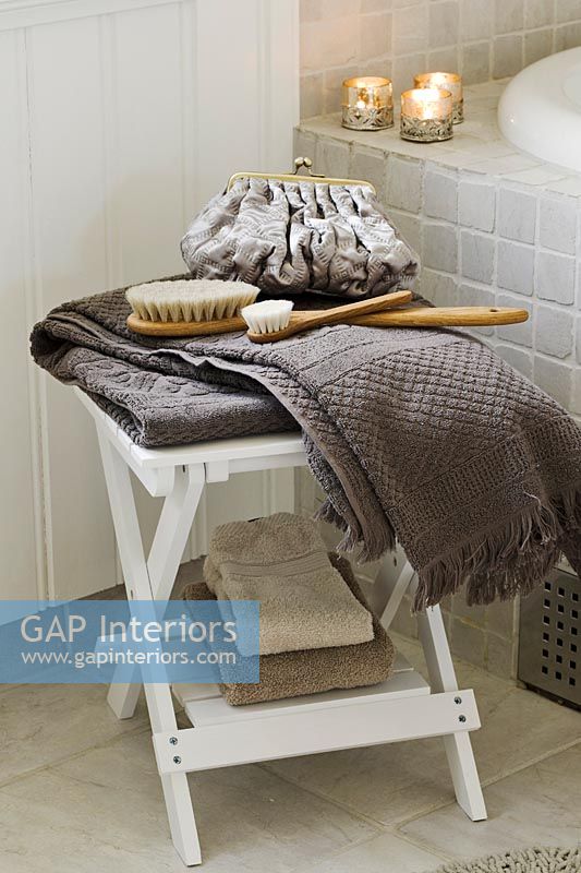 Towels and accessories on bathroom stool 