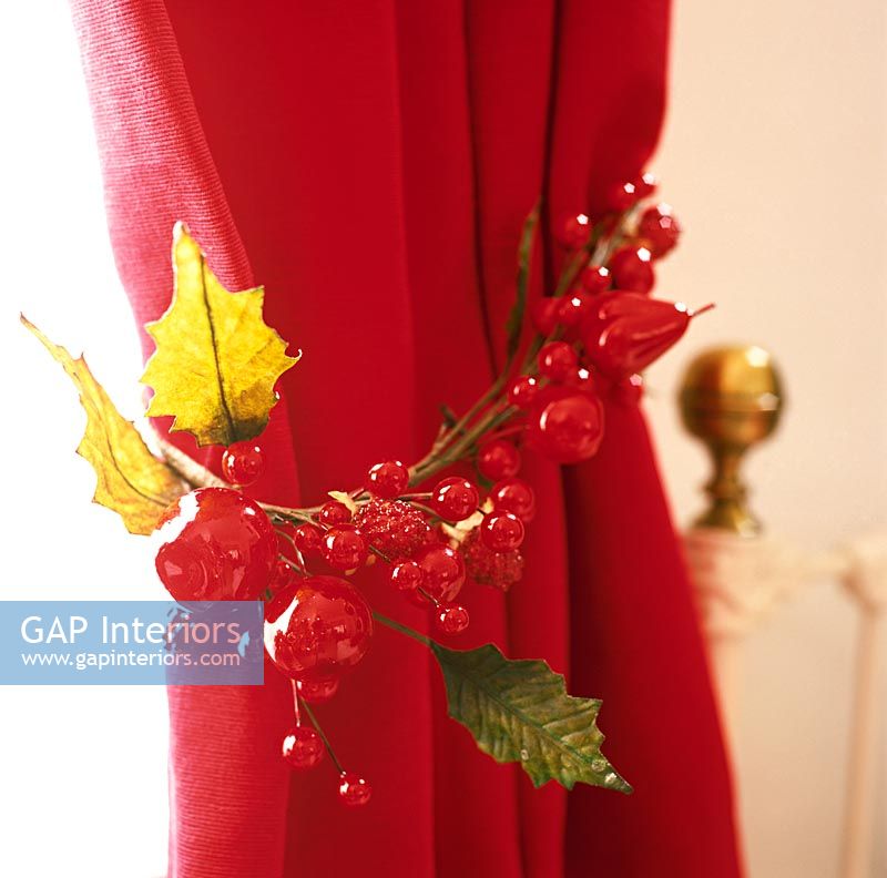 Christmas decoration tied around red curtain  