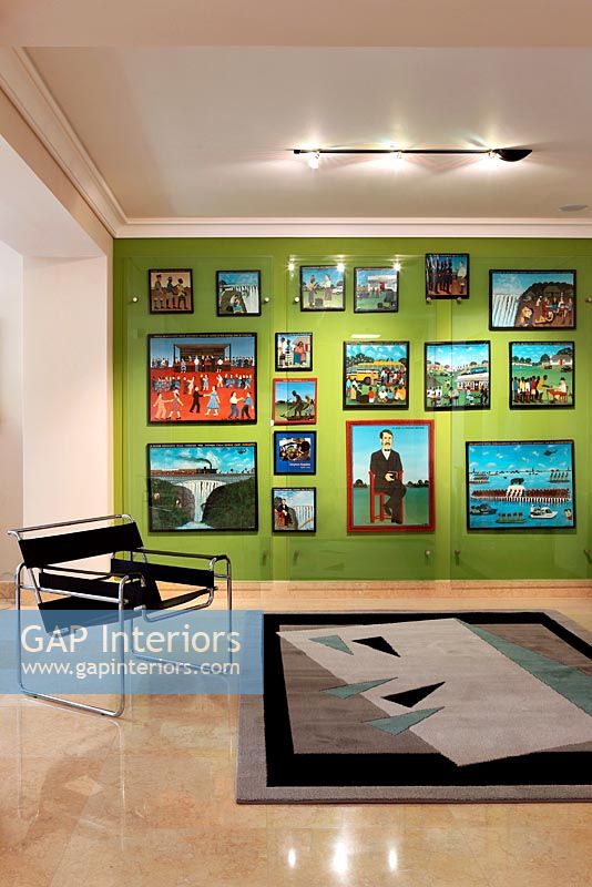 Green feature wall with display of paintings 