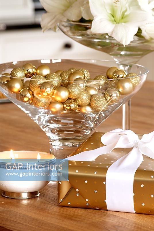 Gold baubles in glass on Christmas table 