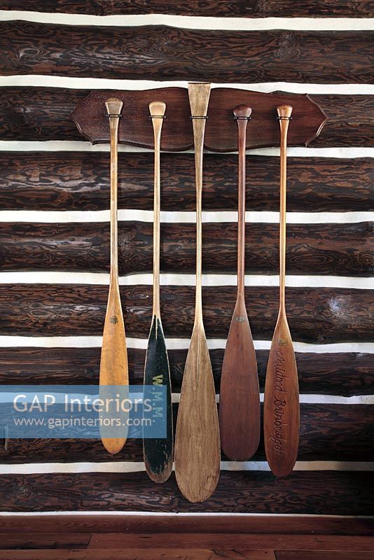 Wooden oars on log cabin wall 