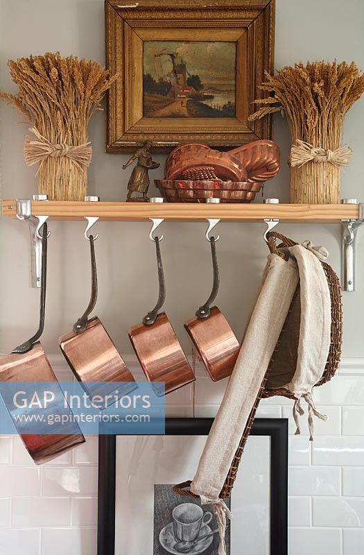 Shelf in country kitchen with copper pans 