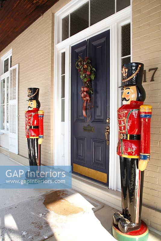 Colourful carved soldiers flanking front door 