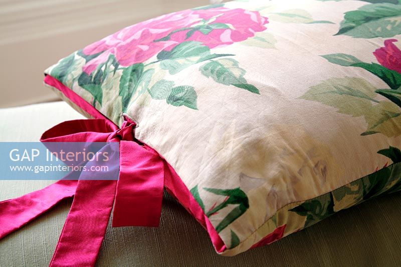 Detail of floral cushion with colourful bow 