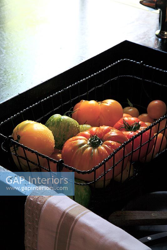 Basket of tomatoes in kitchen sink 