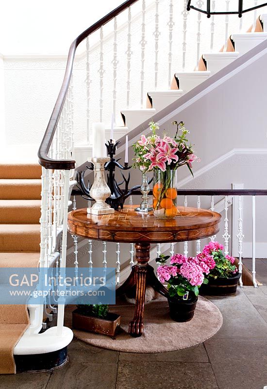 Classic wooden table in hallway by stairs