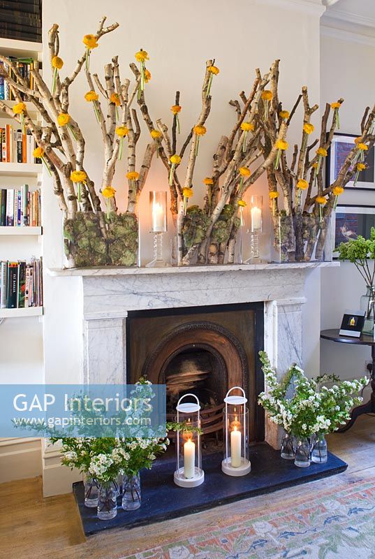 Display of flower arrangements around fireplace