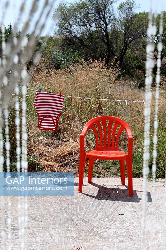 Red plastic chair on terrace