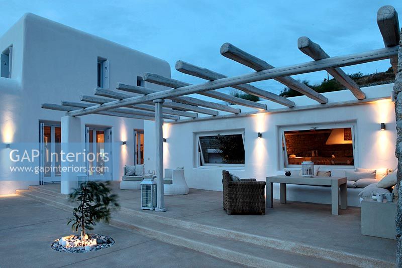 Contemporary white patio lit up at night