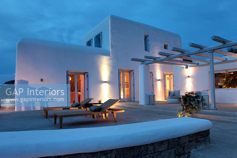 Greek villa and patio lit up at night