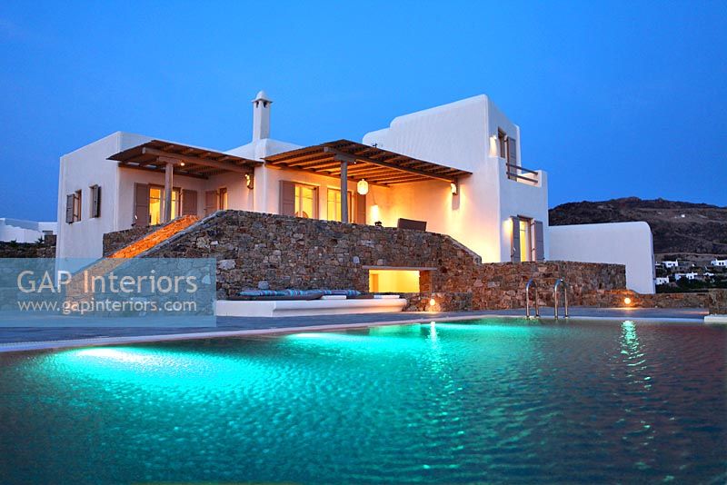 Greek villa and swimming pool lit up at night