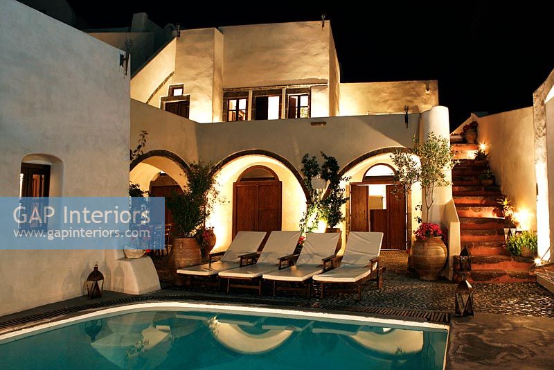 Villa with swimming pool lit up at night
