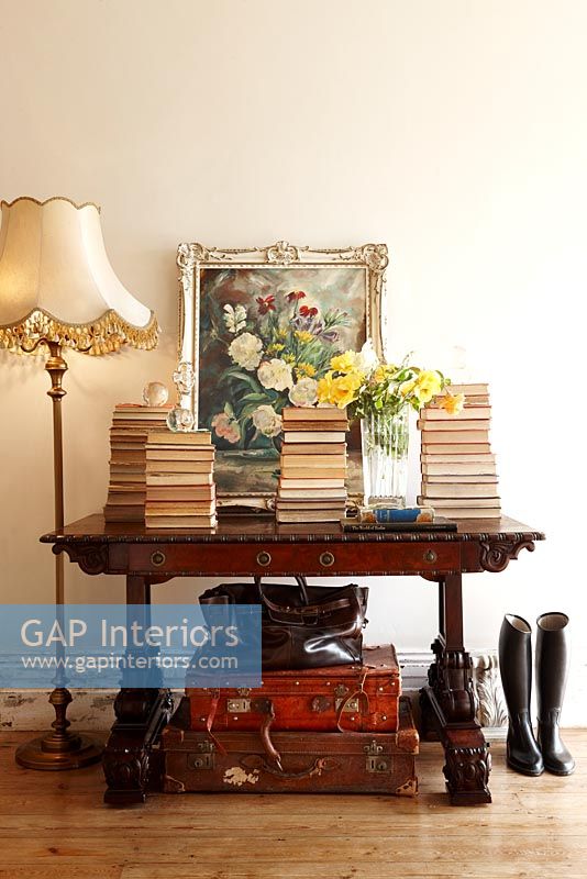 Wooden console table with piles of books