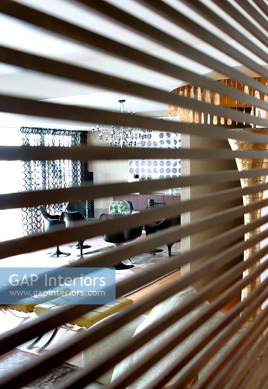 Modern dining room shown through blinds 
