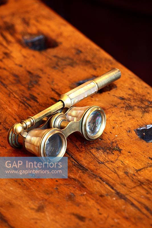 Antique opera glasses on wooden surface
