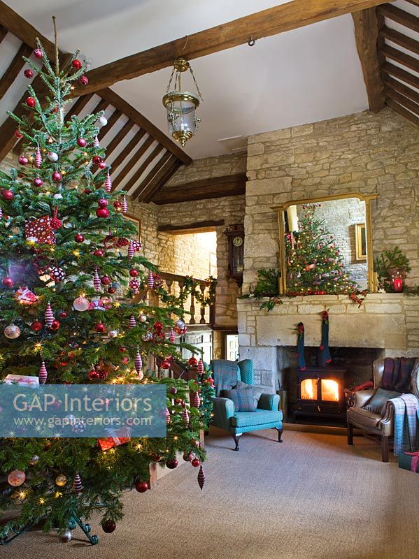 Galleried hall with cotswold stone fireplace at Christmas