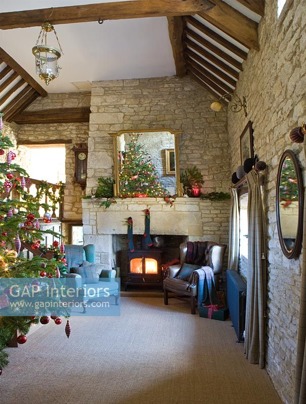 Galleried hall with cotswold stone fireplace at Christmas
