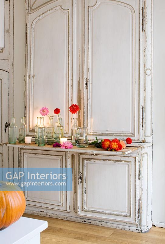 Display of autumnal flowers on vintage french dresser