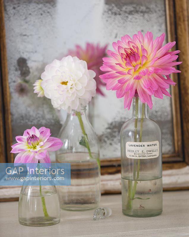 Vintage glass bottles with pink Dahlias on dressing table