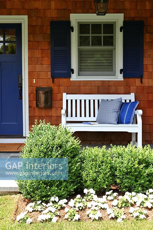 White bench at entrance to cottage