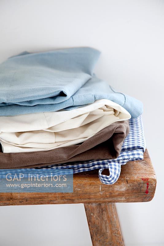 Clothes piled on wooden stool