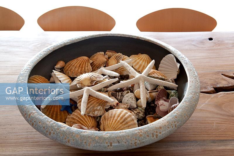 Bowl of seashells on rustic table