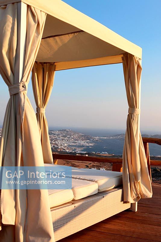 Four poster bed on terrace overlooking sea