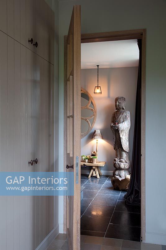 Modern hallway with large wooden statue

