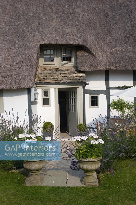 Entrance to cottage with pots of Geraniums and Lavender