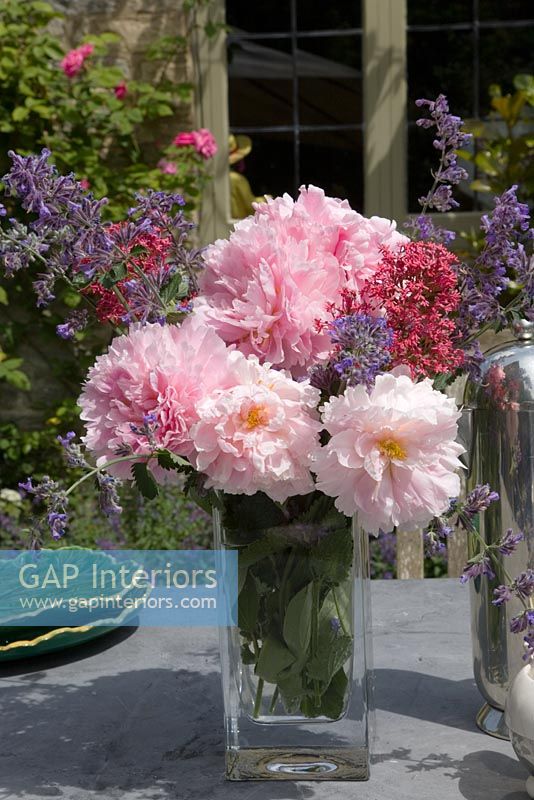 Arrangement of Roses, Catmint and Valerian on garden table